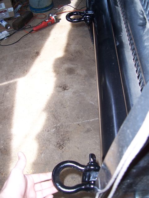 1983 Ford Bronco - Close-up of a black brush guard with two visible tow hooks, one being held by a hand.