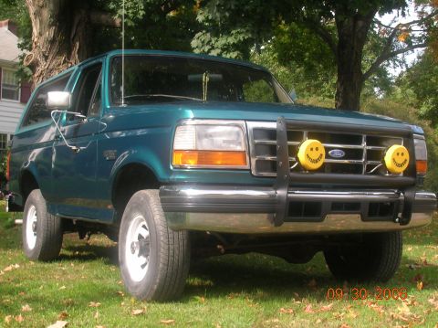 1996 Ford Bronco - This 1996 Ford Bronco is parked on a grassy lawn with trees in the background.