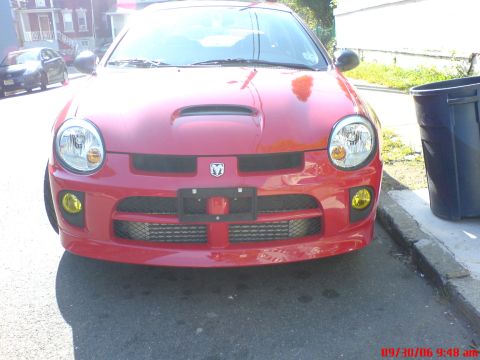 2005 Dodge SRT-4 - Front view of a red 2005 Dodge SRT-4, a distinctive hood scoop and fog lights.