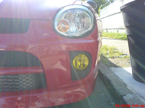 2005 Dodge SRT-4 - Front end of a red Dodge Neon, showing the headlight and fog light assembly.