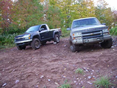 2000 Chevrolet Tahoe - Silver pickup truck with off-road modifications is parked on a dirt road.
