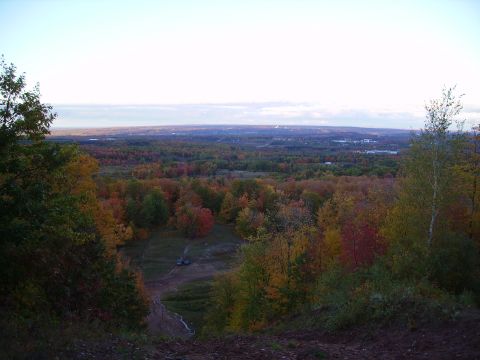 2000 Chevrolet Tahoe - View of a valley during autumn, with a few vehicles on a dirt track below.