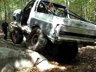 1995 Ford Bronco - Modified 1995 Ford Bronco tackling rough terrain with its custom roll cage and oversized tires.