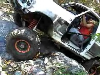 1995 Ford Bronco - This modified off-road vehicle navigates a rocky terrain.