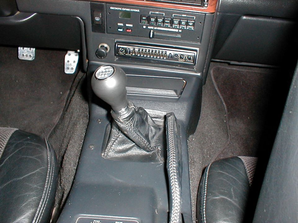 Car interior with manual shifter, radio, and climate controls