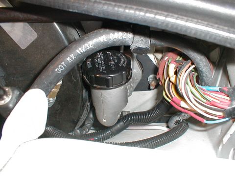 1993 Ford Thunderbird - Engine bay components including the brake fluid reservoir and a bundle of electrical wires are shown in this close-up view.