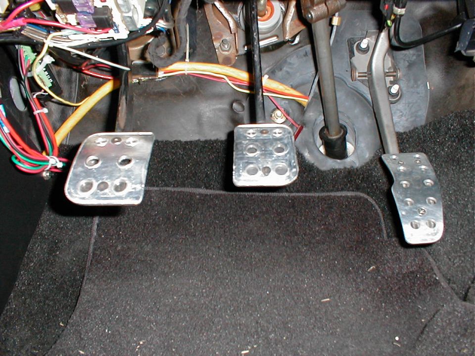 Interior footwell with three pedals and exposed wiring