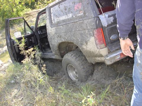 1979 Ford Bronco - This 1979 Ford Bronco is deeply stuck in mud, with its driver's side door open.