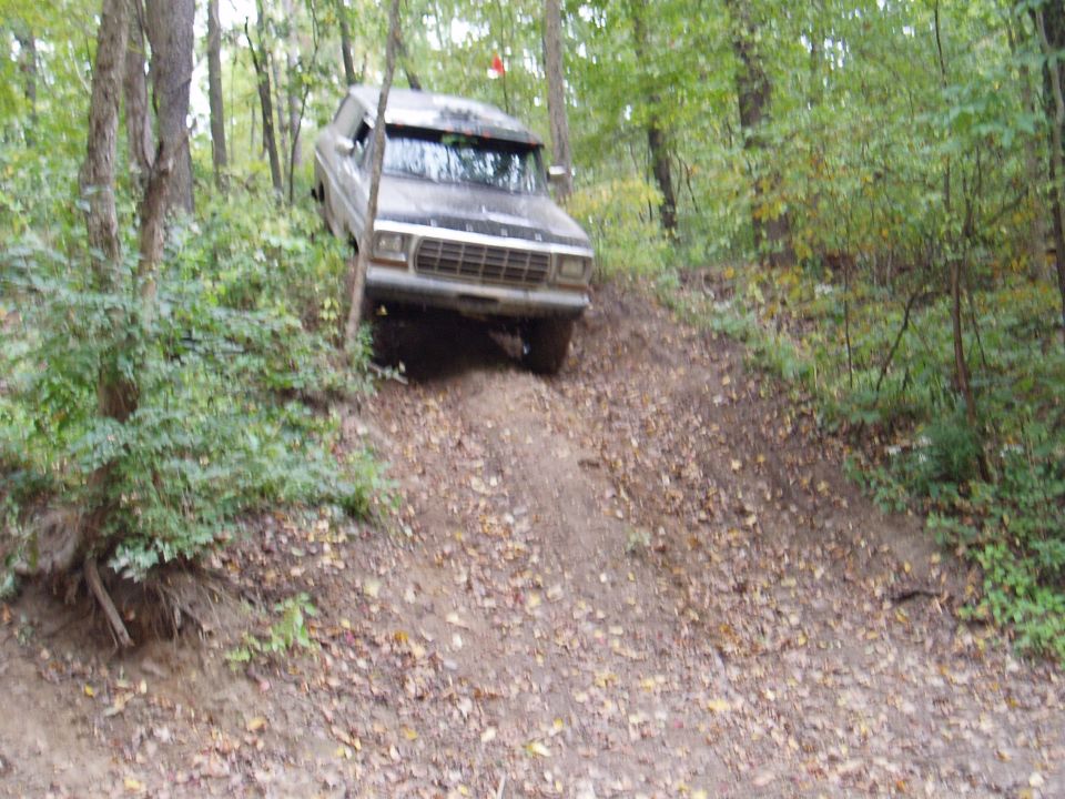 Ford Bronco going up a dirt hill in the woods
