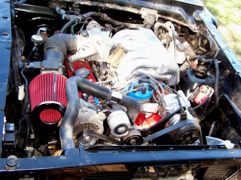 1964 Mercury Comet - Engine bay with V8 engine, red air filter, and various hoses and components visible.