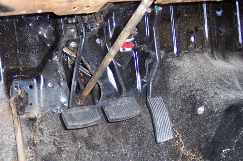 1964 Mercury Comet - The interior floor of a vehicle shows the pedal assembly and associated mechanical linkages.