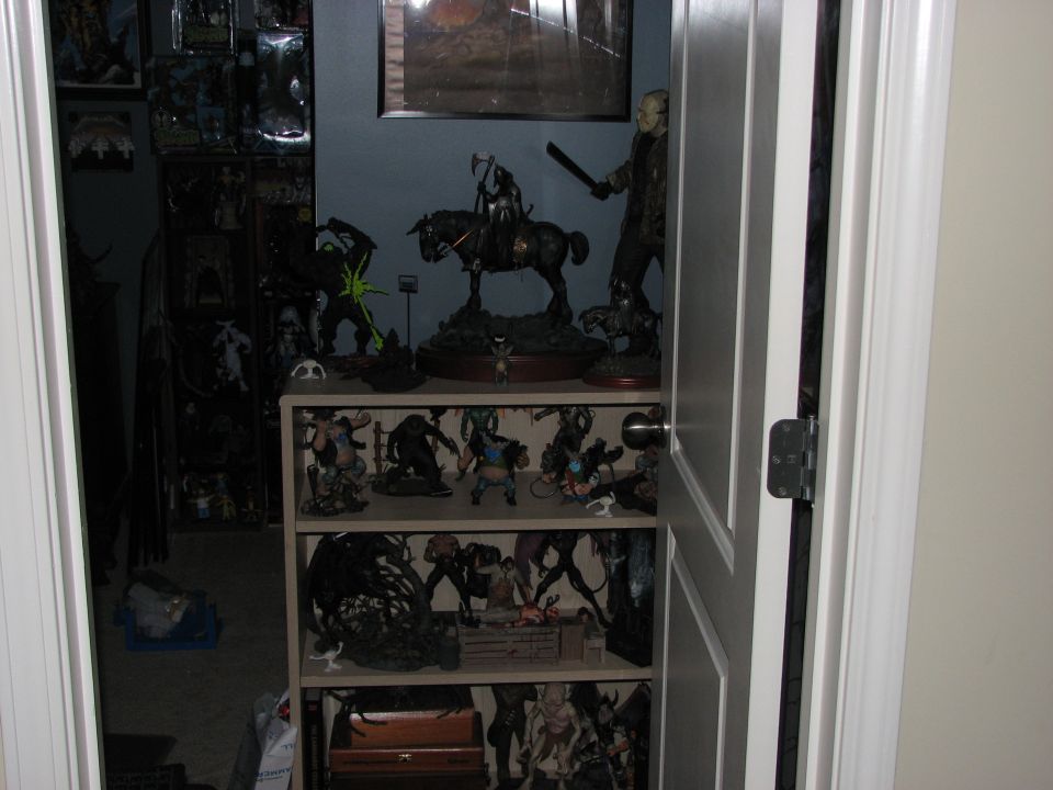 Shelves filled with action figures and statues, including a Jason Voorhees figure and a knight on horseback