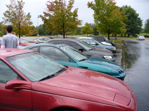 1991 Ford Probe - A red 1991 Ford Probe is parked in a lot with other vehicles on a cloudy day.