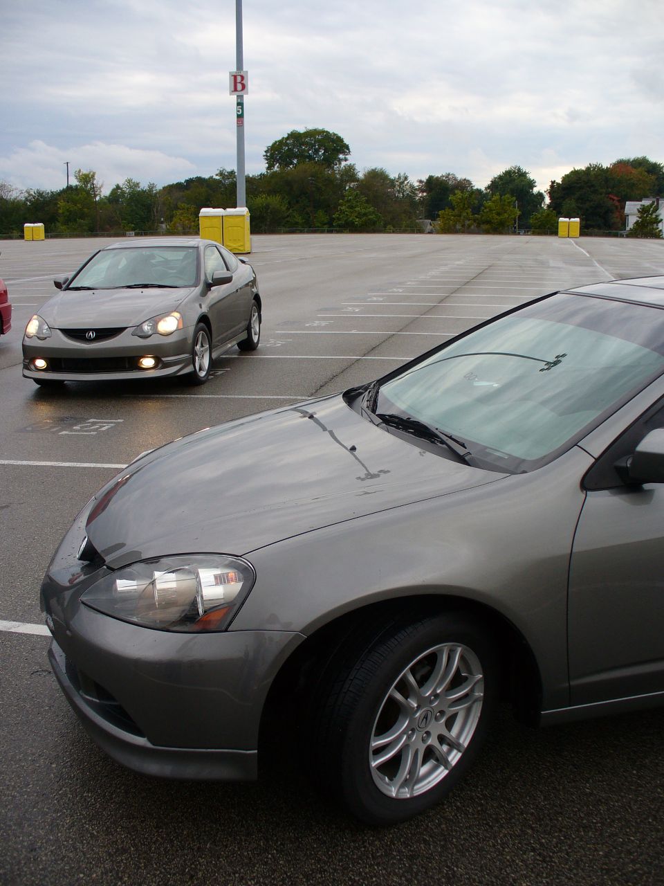 Grey coupe in foreground, another grey coupe in background, parked in lot