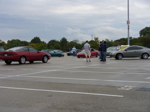 1991 Ford Probe - A red 1991 Ford Probe is seen from the side in a parking lot gathering with several other vehicles.