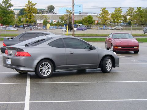 1991 Ford Probe - A gray Acura RSX is parked in a lot next to a red car.