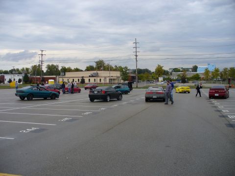 1991 Ford Probe - A teal coupe with a spoiler is seen in a parking lot alongside several other vehicles.