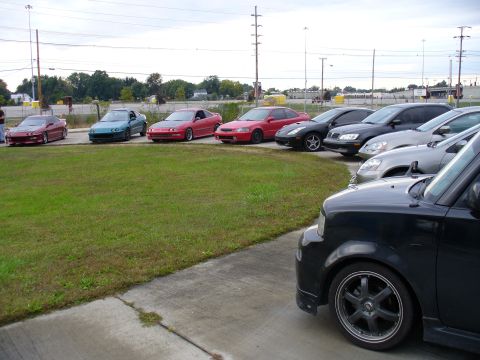 1991 Ford Probe - A variety of vehicles are lined up in a parking lot, with a black car in the foreground.