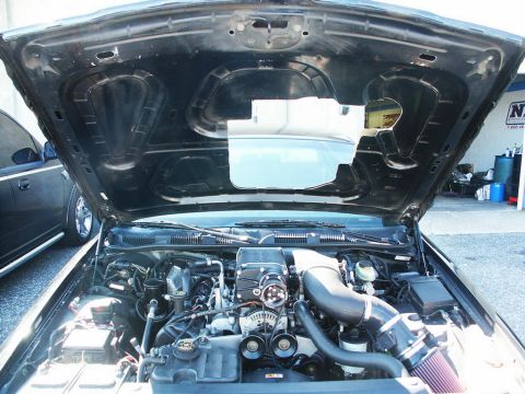 2001 Mercury Grand Marquis - The engine bay of a car is shown with the hood open, revealing a supercharger and other engine components.