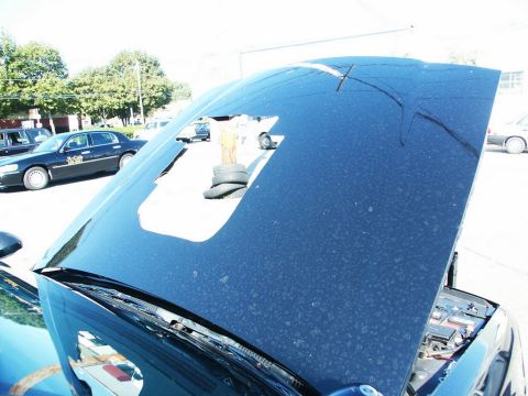 2001 Mercury Grand Marquis - The hood of a car is open, revealing the engine bay. Another car is visible in the background.