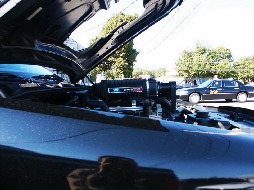 Black 2001 Mercury Grand Marquis engine bay with a supercharger installed, hood open