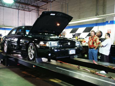 2001 Mercury Grand Marquis - Black 2001 Mercury Grand Marquis on a dynamometer, hood open, with two men observing.