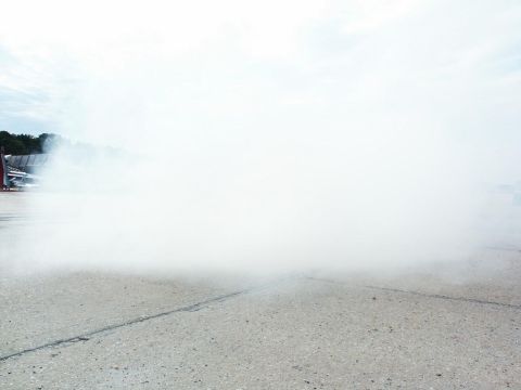 2001 Mercury Grand Marquis - A large cloud of smoke obscures the scene, with a hint of a vehicle visible on the left.