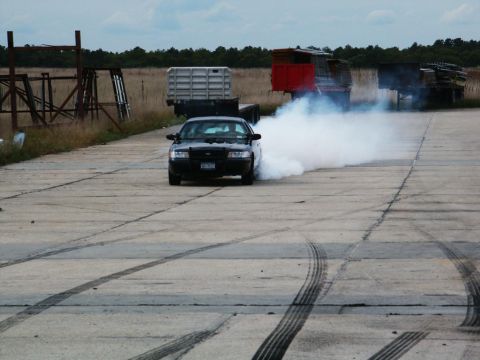 2001 Mercury Grand Marquis - A black 2001 Mercury Grand Marquis performs a burnout, kicking up a large cloud of smoke.