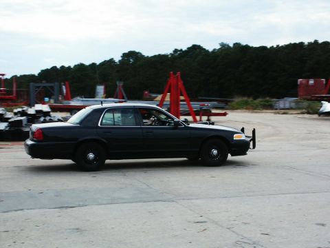 2001 Mercury Grand Marquis - A black 2001 Mercury Grand Marquis sedan is seen from the side, equipped with a push bumper.