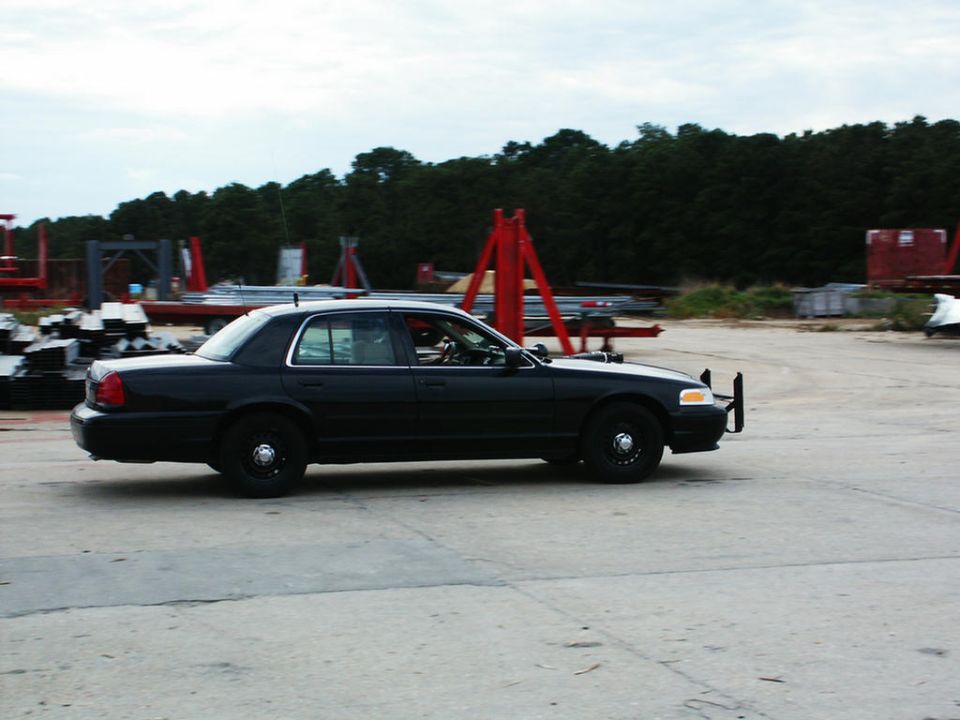 Black 2001 Mercury Grand Marquis sedan with push bumper, side view