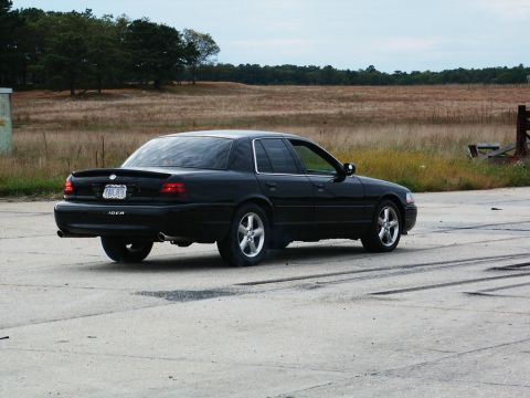 2001 Mercury Grand Marquis - Black 2001 Mercury Grand Marquis with a spoiler is parked on a paved surface.