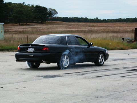 2001 Mercury Grand Marquis - A black 2001 Mercury Grand Marquis performs a burnout, kicking up smoke.