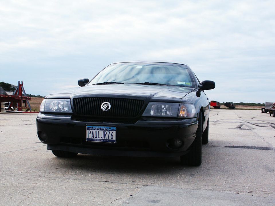 Black sedan with a black grille and a New York license plate reading PAULJR76