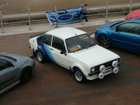 2001 Ford Fiesta - White Ford Escort Mk2 with blue side stripes and rally lights parked outdoors.