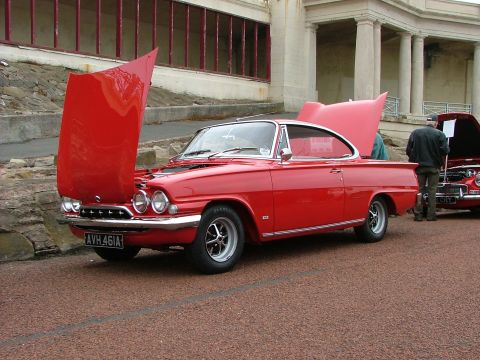 2001 Ford Fiesta - A vintage red coupe with its hood raised is displayed outdoors, with another vehicle visible to the right.