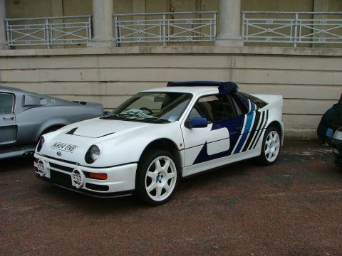 2001 Ford Fiesta - This white rally car, likely a Ford RS200, features distinctive blue and black racing stripes and auxiliary driving lights.