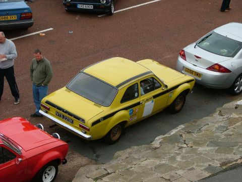 2001 Ford Fiesta - A yellow Ford Escort Mk1 rally car is parked in a lot with other vehicles.