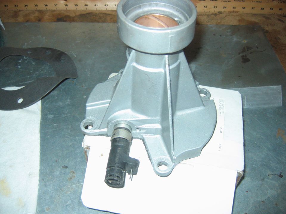 Cast-aluminum transmission tail housing with bronze bushing and speed sensor on a workbench