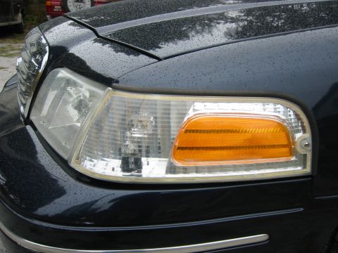 1999 Ford Crown Victoria - Close-up of a car's front corner, the headlight and turn signal assembly.