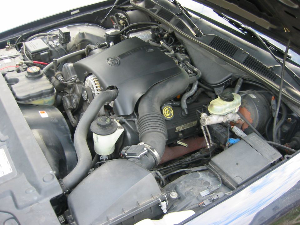 1999 Ford Crown Victoria engine bay with V8 engine cover, air intake, and brake fluid reservoir visible