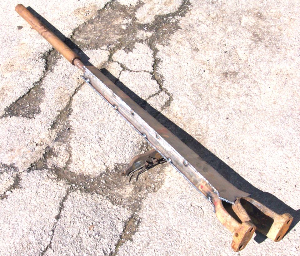 Custom metal part with wooden handle on concrete