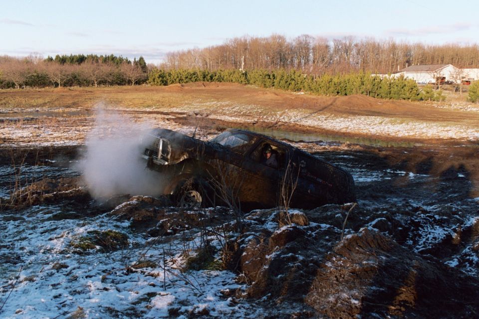 Wrecked 1979 Ford Bronco emitting steam in a snowy field