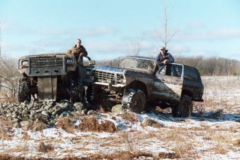 1979 Ford Bronco - Two heavily modified Ford Broncos from 1979 are shown off-road in the snow.