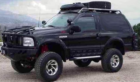 1987 Ford Bronco - This heavily modified Ford Excursion features an aftermarket bumper and roof rack.