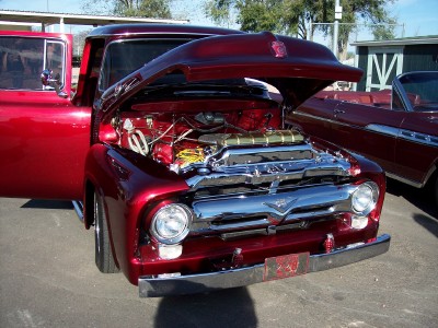 1972 Ford Ranchero - A red 1955 Ford F-100 pickup truck is displayed with its hood open, revealing a customized engine.