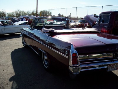 1972 Ford Ranchero - A maroon 1963 Buick Wildcat convertible is parked outdoors with other vehicles.