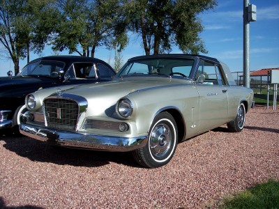 1972 Ford Ranchero - A silver 1957 Studebaker Golden Hawk coupe is parked outdoors next to another vehicle.