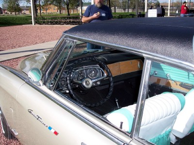 1972 Ford Ranchero - The interior of a classic car shows a wood-grain dashboard and two-tone seating, with a badge on the fender.