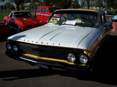 1972 Ford Ranchero - A 1960 Chevrolet Biscayne sedan is parked next to a red convertible and a red van.