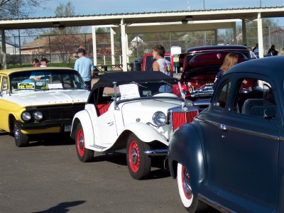1972 Ford Ranchero - A white convertible with red accents is parked alongside other vehicles at an outdoor gathering.